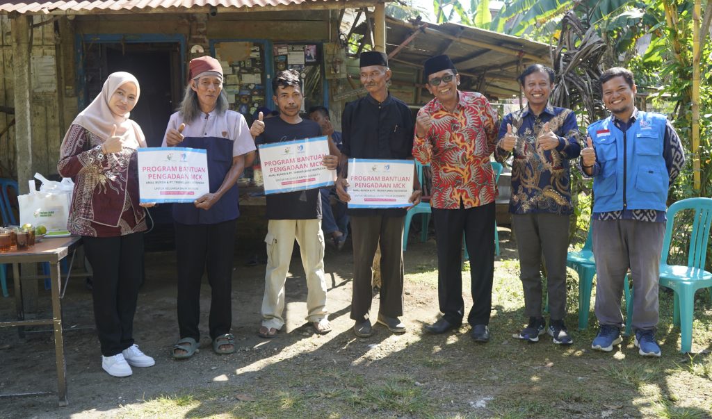 Warga penerima bantuan menunjukkan kamar mandi yang telah diperbaiki
